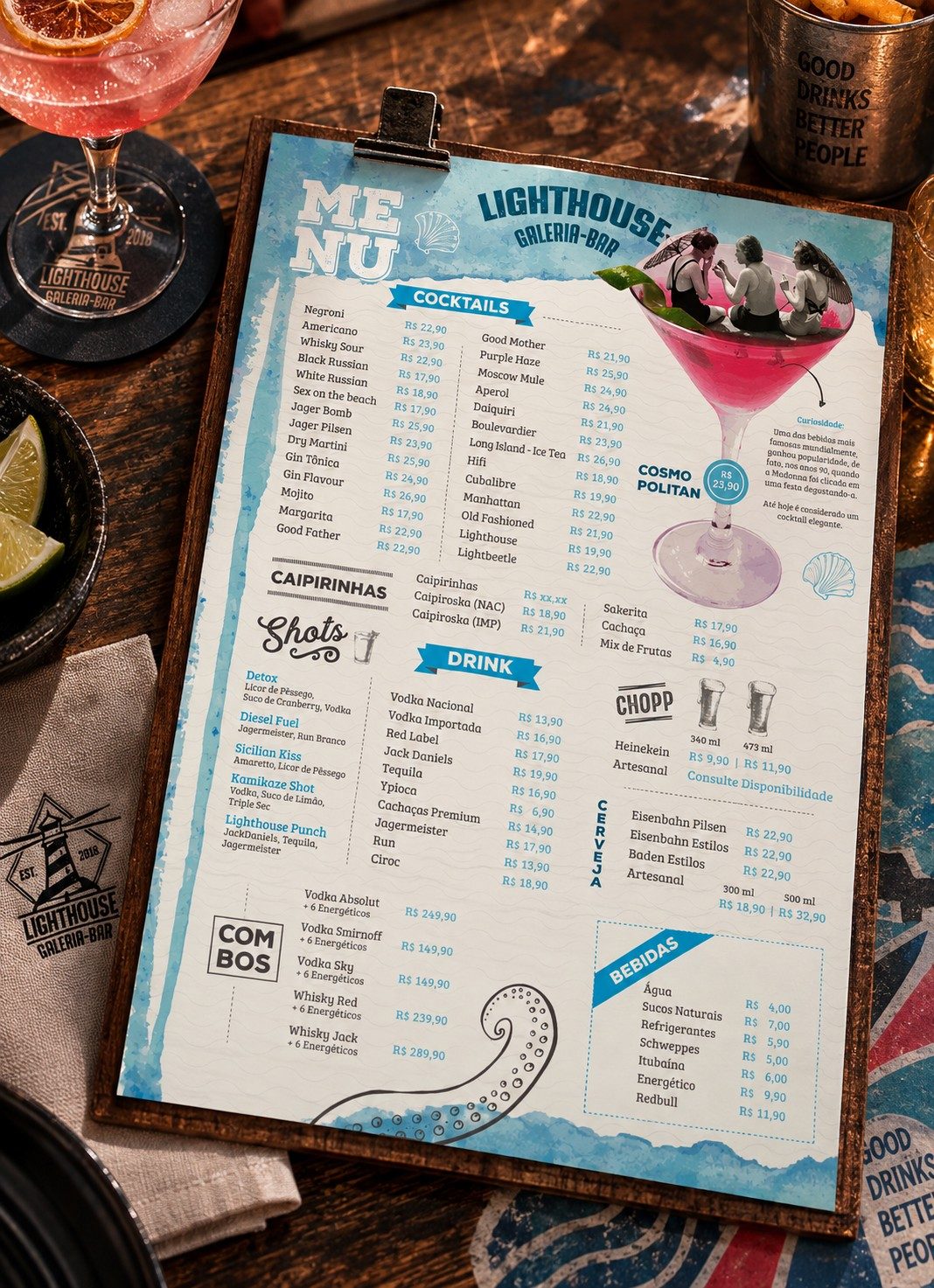 Menu Bar Lighthouse drinks menu on a clipboard on the bar table, next to a cocktail, a beer and a lime