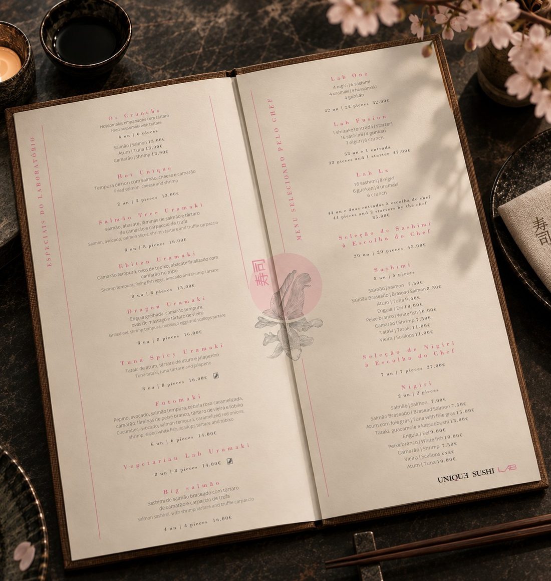 Unique Sushi Lab menu open on a restaurant table next to chopsticks, soy sauce and cherry blossoms